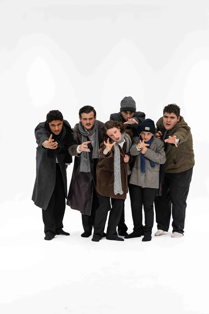 The Hooverville cast leaning forward in character