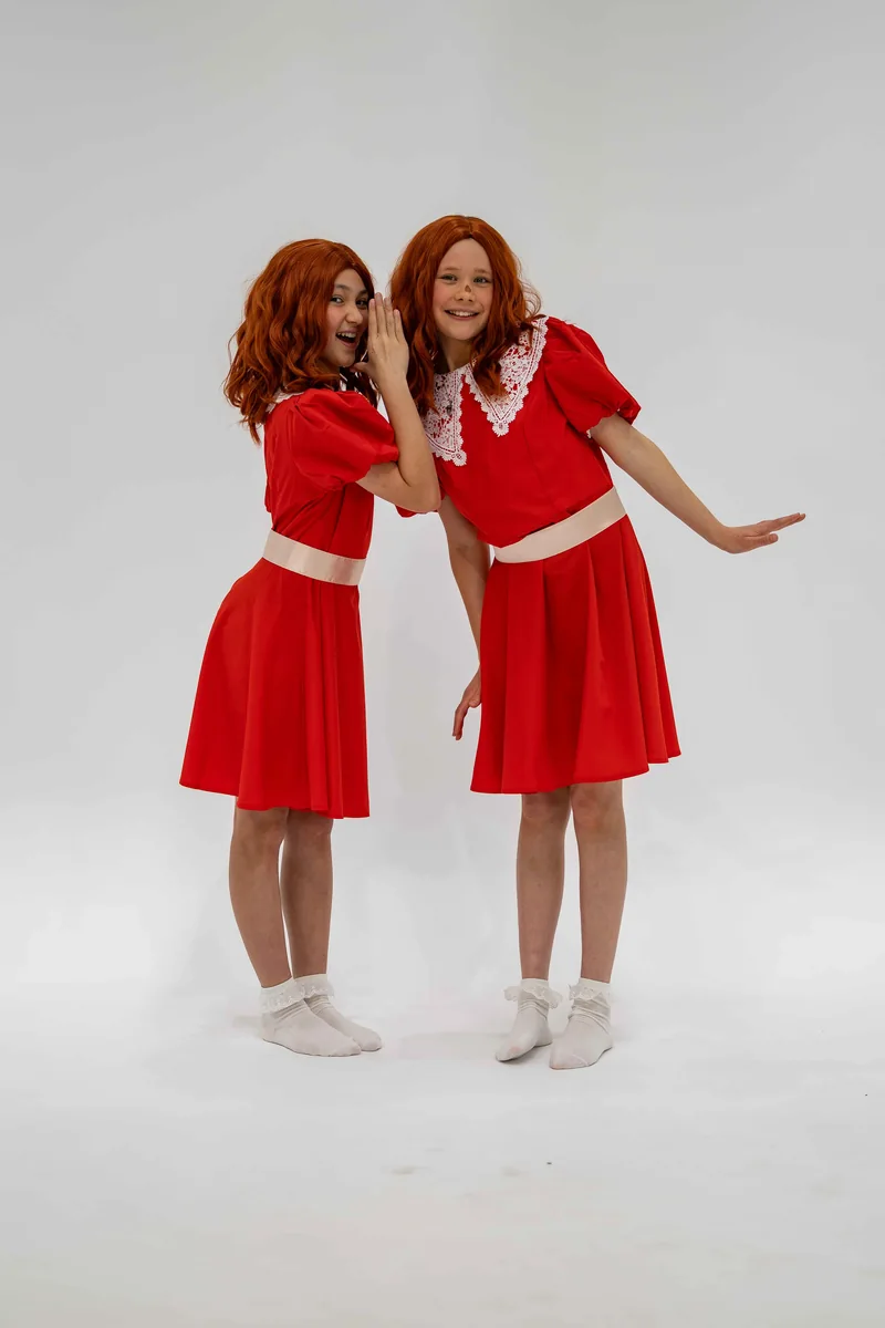Both Annies sharing a playful secret