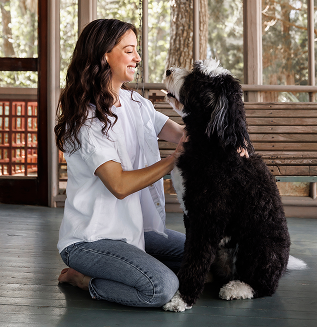 woman and shaggy white and black dog