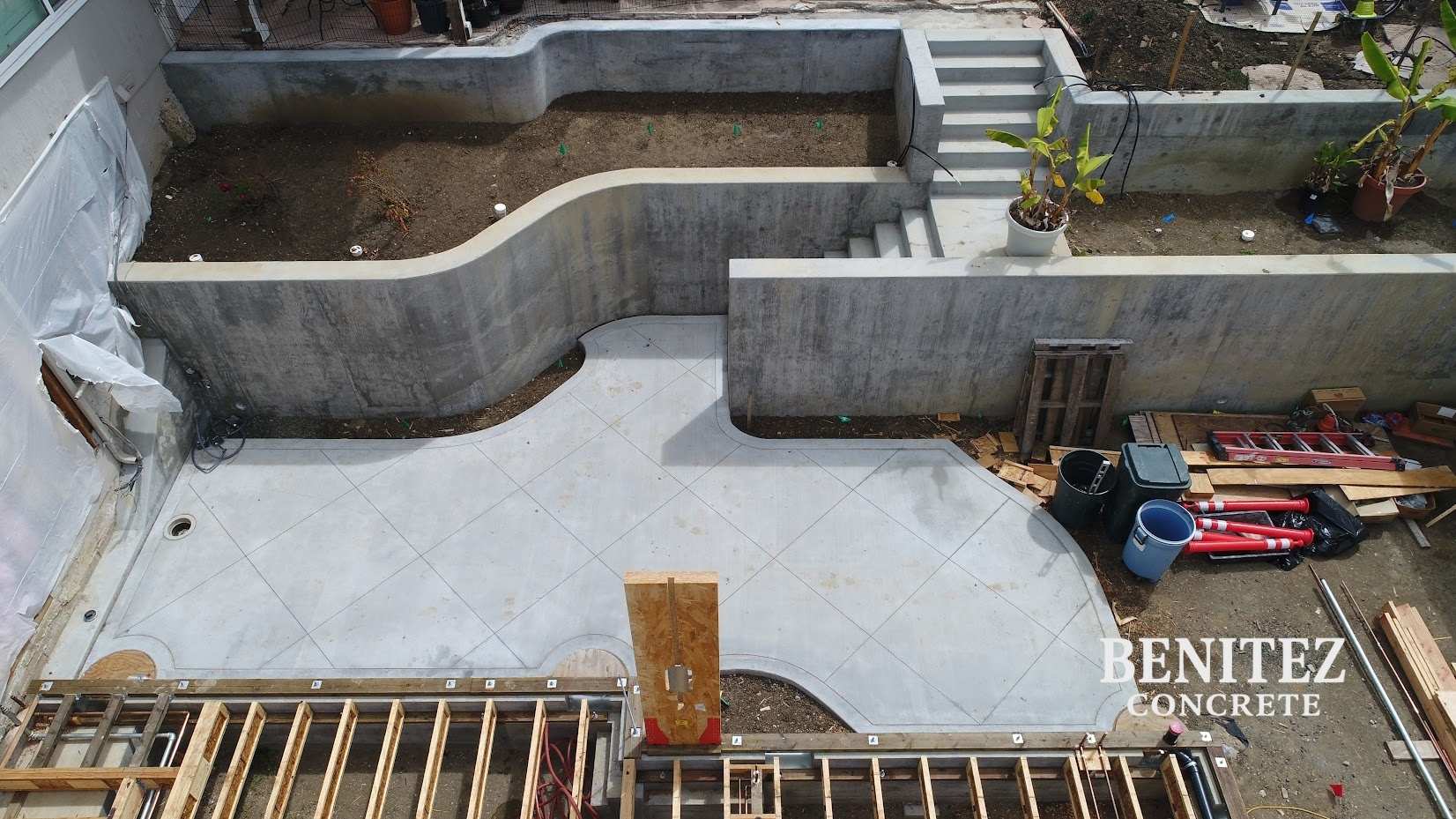 Terraces with retaining wall and styled concrete slab at the bottom of concrete stairs