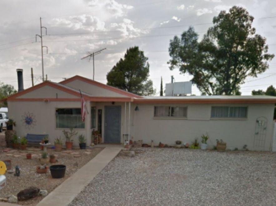 Single-story home with dated exterior and minimal landscaping, ideal for a fixer-upper sale.