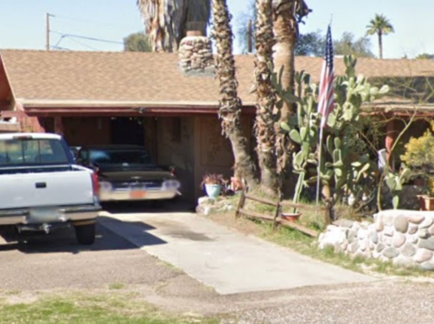 Older home with carport and desert landscaping, suitable for an as-is home sale.