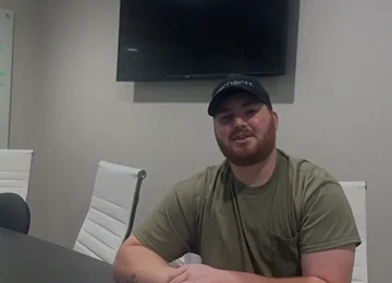 Homeowner sitting in a Joe Homebuyer office, sharing their selling experience.