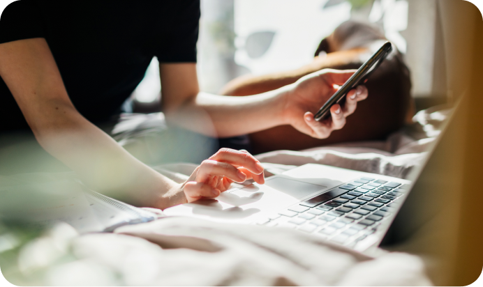 Person in checking their phone and laptop