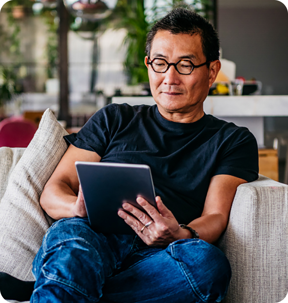 Man is sitting on the couch and browsing on tablet 