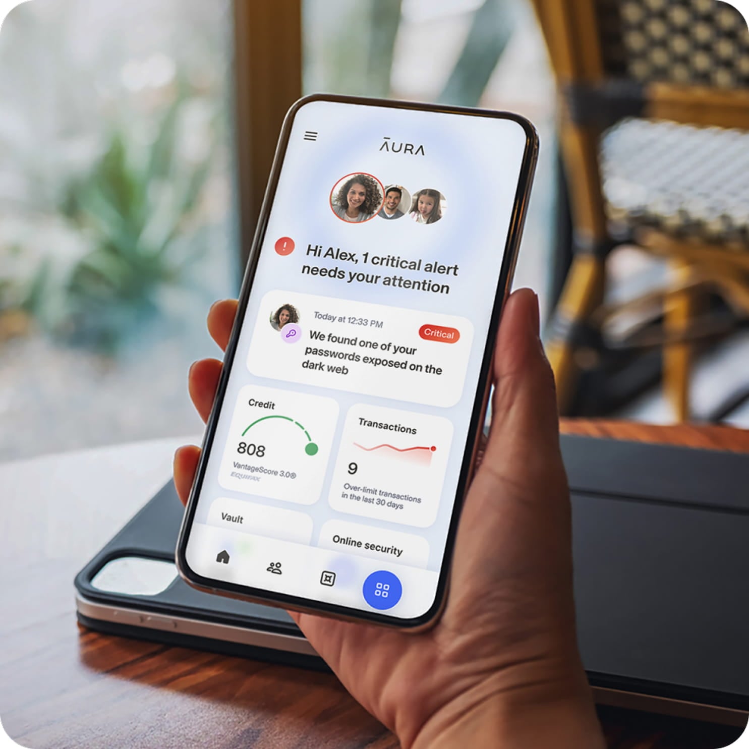 Hand holding phone with Aura dashboard displayed.